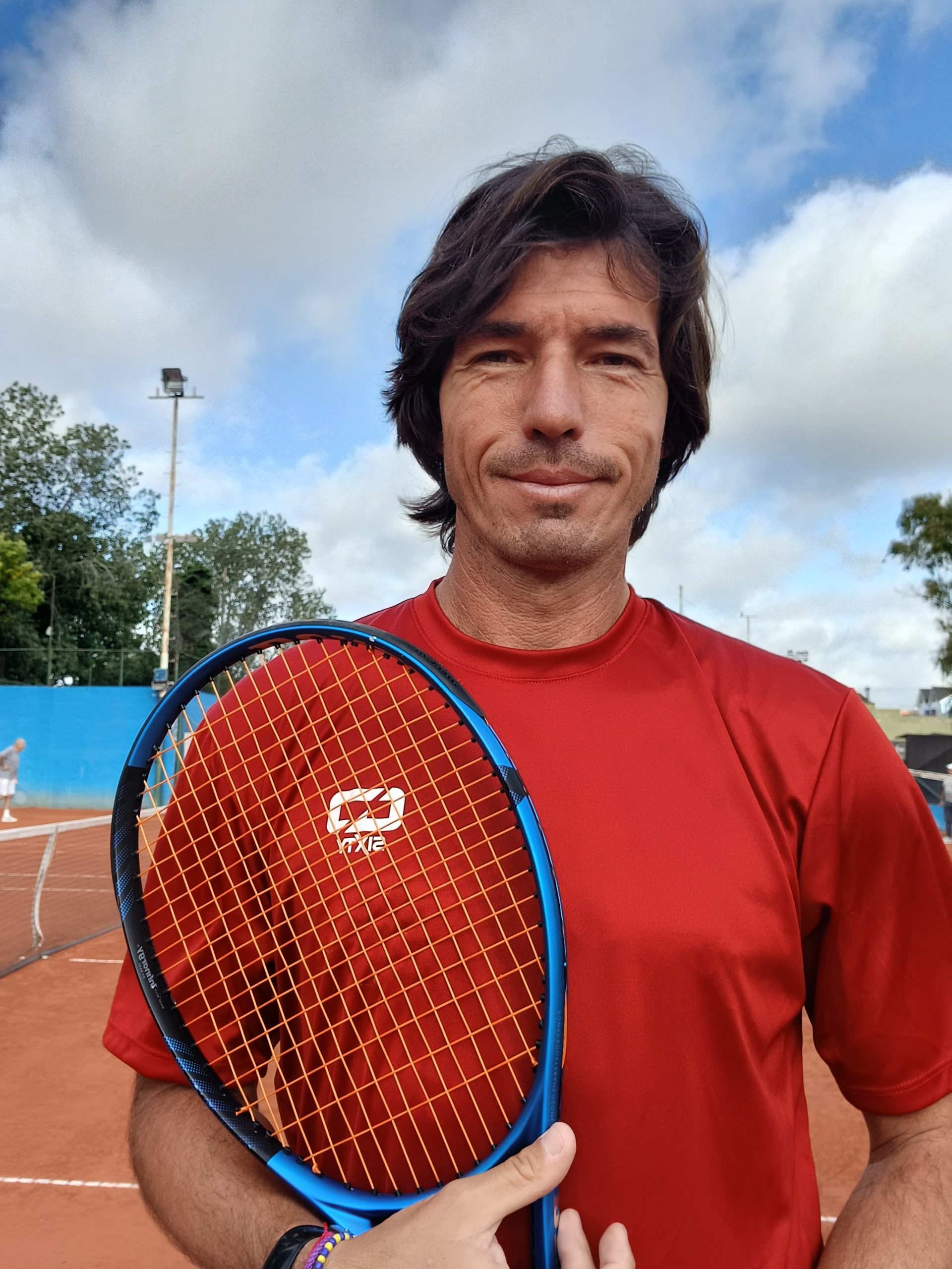 Gustavo Parodi en cancha de tenis sosteniendo una raqueta